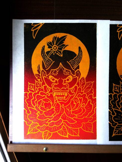 Xilogravura Hannya e Peônias - Máscara Hannya com brilho da lua ao fundo e cercada por flores de Peônia. Materiais: Xilogravura / Gravura em madeira.
