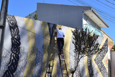Ornamentação Caligráfica e Geométrica - Ornamentação Caligráfica Chanfrada 45°, nas cores preto e dourado, aplicada em estrutura Geométrica, sobre fundo cinza. Caligrafite. Arte Mural.